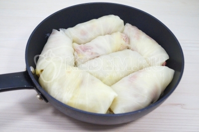 Выложить голубцы в глубокую сковороду.