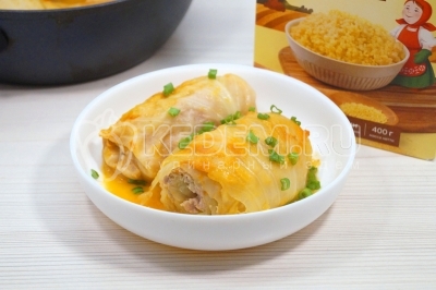 Готовые голубцы выложить на блюдо и украсить зеленым луком.