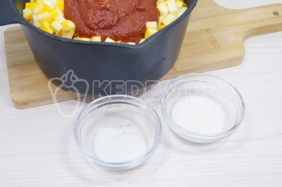 Сложить в сотейник овощи. Добавить томатную пасту с водой. Добавить 1 чаную ложку соли и 1 столовую ложку сахара.