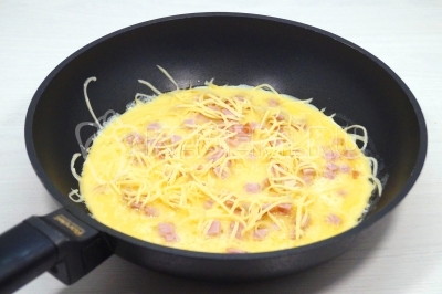 Выложить сверху ветчину, тертый сыр и зеленый лук.