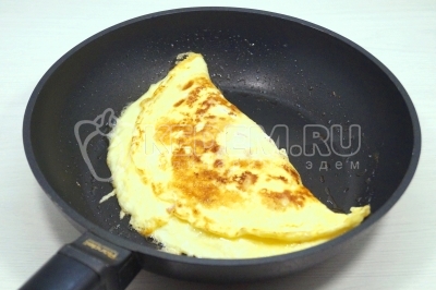 Свернуть омлет пополам. Готовить еще 2 минуты.