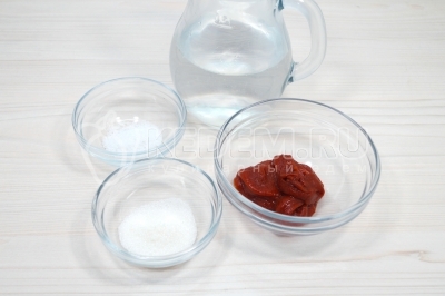 В другой миске смешать 3 столовые ложки томатной пасты, 1/4 чайной ложки соли, 1/2 чайной ложки сахара и 300 миллилитров воды.