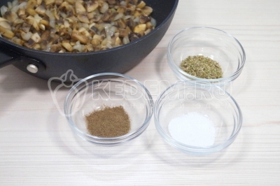 Добавить в сковороду к грибам с луком 1/2 чайной ложки соли, черный молотый перец по вкусу и 1/4 чайной ложки сушеного орегано. Хорошо перемешать.