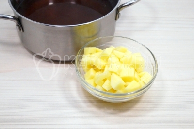 В кастрюлю с грибным бульоном добавить 2 картофелины нарезанные кубиком и еще 1 литр воды. Варить 4-5 минут.