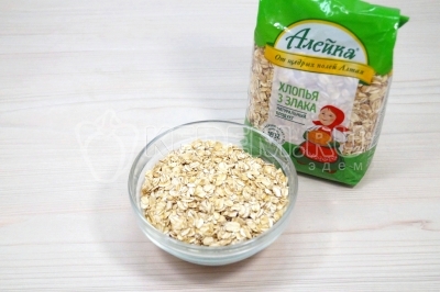Чтобы приготовить овсяную кашу с апельсином и изюмом, нужно в небольшую миску отмерить 140 грамм овсяных хлопьев три злака.
