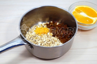В сотейнике смешать овсяные хлопья, цедру апельсина и изюм.