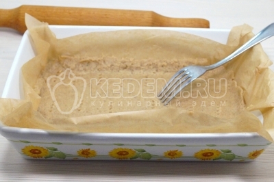Выложить в форму для запекания тесто с пергаментом. Наколоть тесто вилкой. Пока готовим начинку, убрать форму с основой в холодильник.