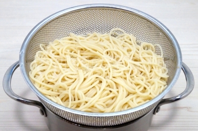 Откинуть спагетти на сито и дать воде полностью стечь.