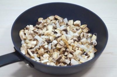 На сковороде разогреть 3 столовые ложки подсолнечного масла и обжарить грибы с луком, помешивая, 5-7 минут. Посолить и поперчить по вкусу.