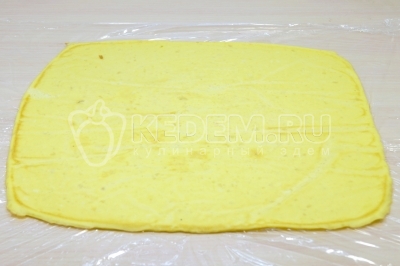 Накрыть сверху пищевой пленкой. Перевернуть яичный пласт на пленку и убрать противень. Снять пергамент.