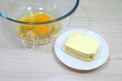 Чтобы приготовить маффины с сыром и зеленью, нужно в миске смешать 3 яйца и 100 грамм сливочного масла.