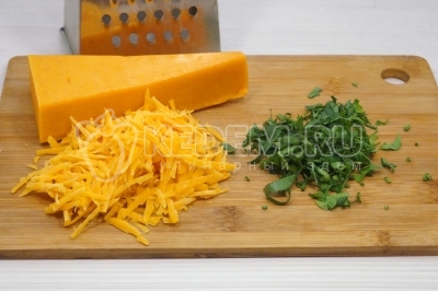 На крупной терке натереть 100 грамм твердого сыра и мелко нашинковать пучок зелени петрушки.