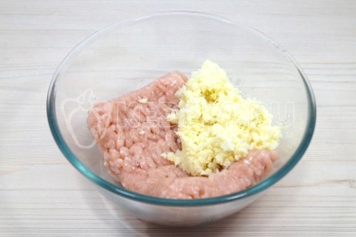 В миске смешать 400 грамм куриного фарша и лук с сыром.