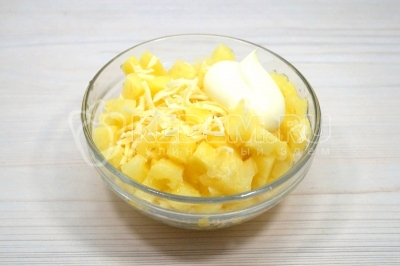 В миске смешать ананасы, тертый сыр и 2 столовые ложки майонеза. Перемешать.