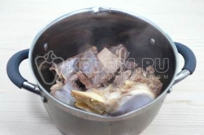 Слить первый бульон. Кастрюлю и кости промыть и сложить обратно.