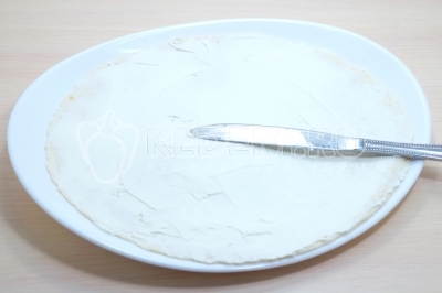 Хорошо смазать лаваш плавленым сыром.