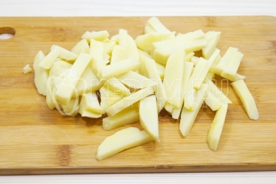 Нарезать запеченный картофель соломкой.