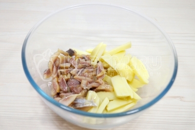 В миске смешать картофель и нарезанное филе сельди.