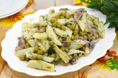 Салат с селедкой, запеченным картофелем и горошком готов. Выложить в салатник и подавать к столу.