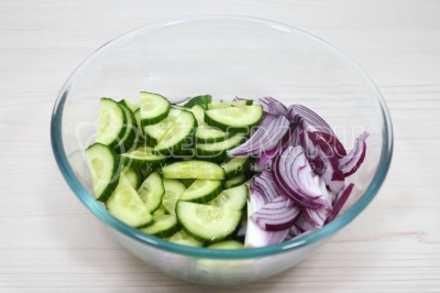 Чтобы приготовить Салат Зеленый великан с огурцом и шпинатом нужно в большую миску нарезать полукольцами красную луковицу и 2 огурца.