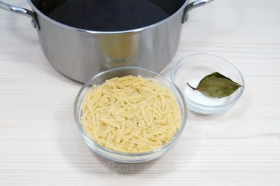 В бульон добавить 80 грамм лапши, 1/2 чайной ложки соли и 1-2 лавровых листа.