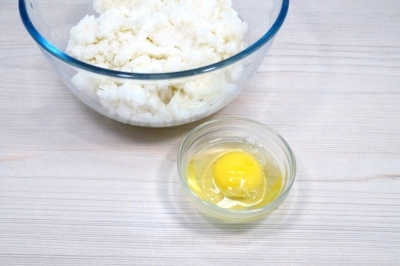 Переложить рис в миску. Добавить 1 яйцо и перемешать.