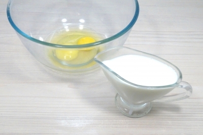 Чтобы приготовить блины с вареной сгущенкой и грецкими орехами, нужно в миске смешать 2 яйца и 400 миллилитров молока.