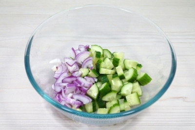 Чтобы приготовить салат с рукколой, помидорами черри и бальзамическим соусом, нужно красную луковицу и свежий огурец разрезать на четвертинки и нарезать небольшими кусочками.