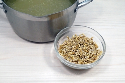 В бульон добавить набухшую перловку. Варить на среднем огне 15 минут.