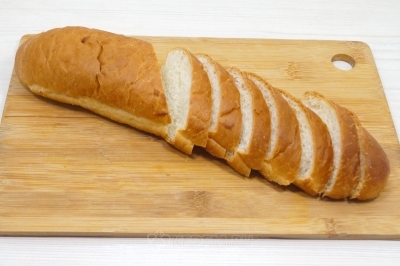 Чтобы приготовить бутерброды с щучьей икрой, нужно батон нарезать тонкими ломтиками.