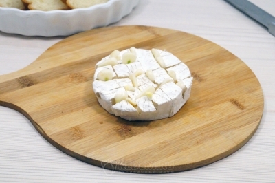 Вставить в сыр ломтики чеснока.