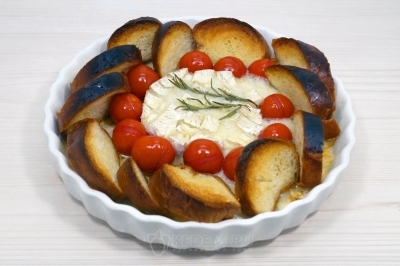 Вынуть запеченный камамбер из духовки.