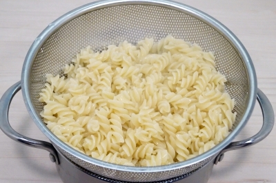 Откинуть макароны на дуршлаг и дать воде полностью стечь.