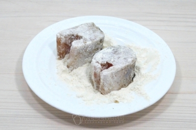 Запанировать кусочки судака в муке.
